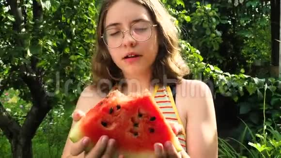 戴眼镜的小女孩在花园里吃西瓜视频的预览图