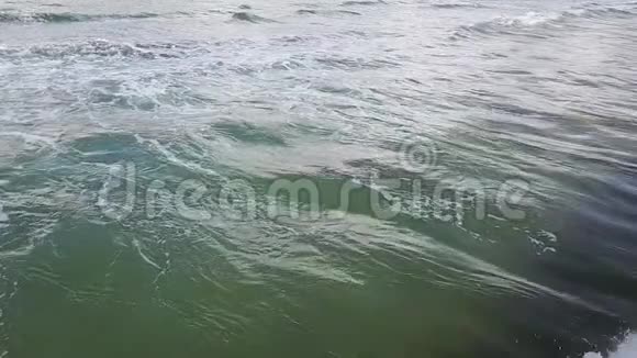 波浪的翻滚变成了浪花和泡沫空中勘测慢动作视频的预览图