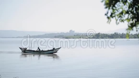 非洲男人坐在船上独自划船在海里工作的渔夫视频的预览图