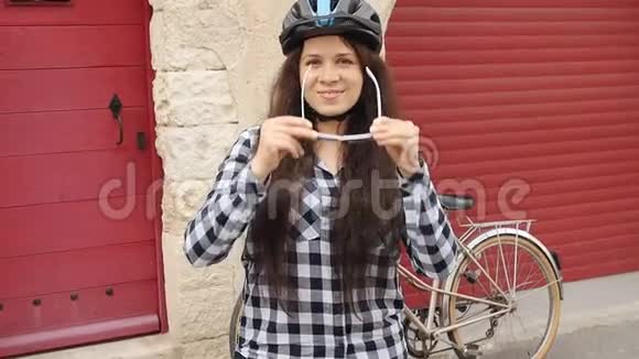 年轻的骑自行车的女性戴着眼镜戴着头盔微笑着看着摄像机视频的预览图