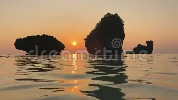 印度洋海岸浪漫日落岩石从水面上升起海面上泛起涟漪悬崖倒影视频的预览图