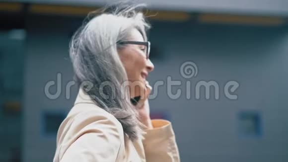 在电话中讲话的亚洲中年妇女视频的预览图