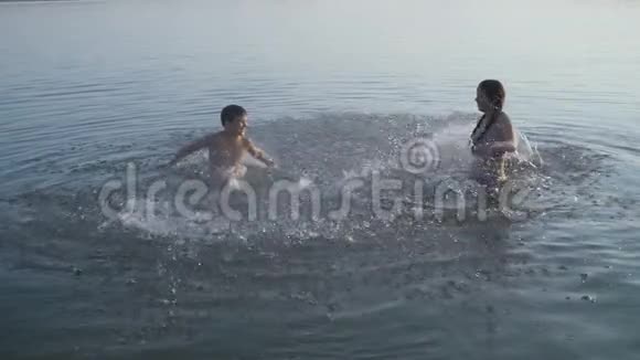 日落时分两个孩子在河里泼水视频的预览图
