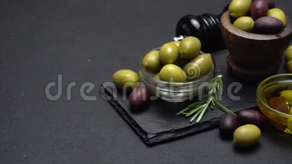 黑色和绿色橄榄和油在石头上视频的预览图