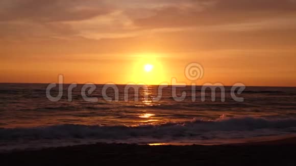 日落时海水波涛汹涌的沙滩视频的预览图