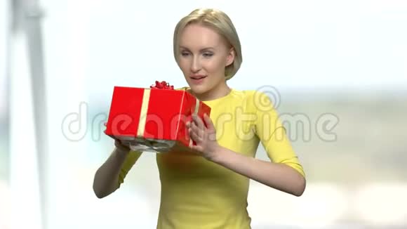 年轻兴奋的女人拿着红色的礼盒视频的预览图