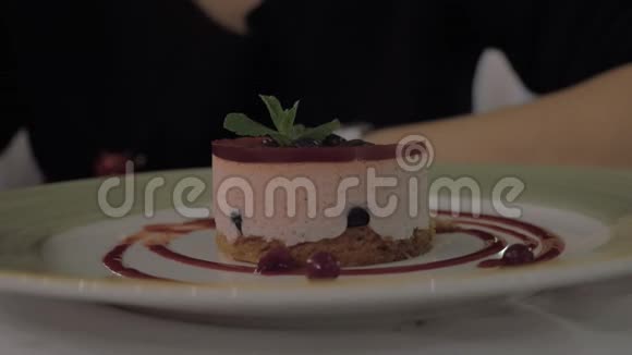 在餐厅吃慕斯甜点和浆果的女人视频的预览图