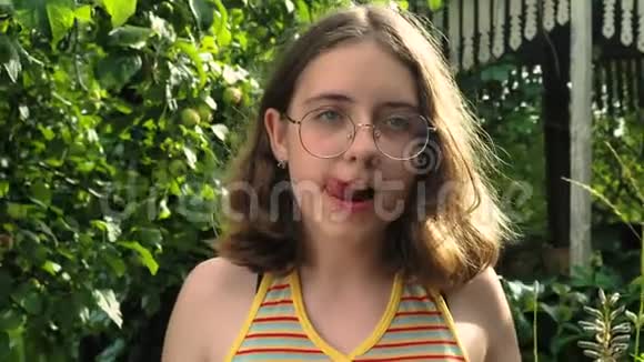 戴眼镜的小女孩在花园里吃西瓜视频的预览图