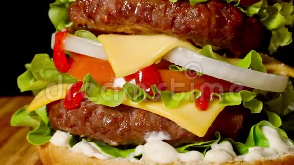 家庭制作的牛肉汉堡和生菜和蛋黄酱的特写在小木砧板上深色背景视频的预览图