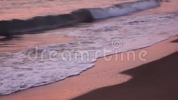 绚丽的波浪在夕阳下的沙滩上形成泡沫关门视频的预览图