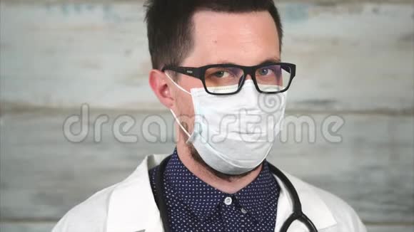 医生带着严格的眼神戴眼镜和戴医药面具的人的肖像视频的预览图
