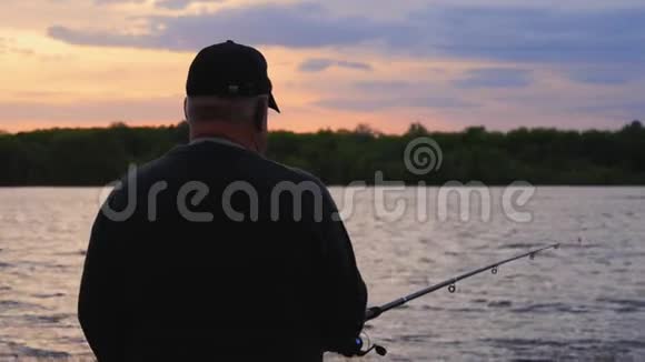 剪影渔夫在黎明时在河里扔了一个渔具视频的预览图