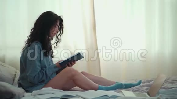 早上床上有书和咖啡的黑发美女视频的预览图
