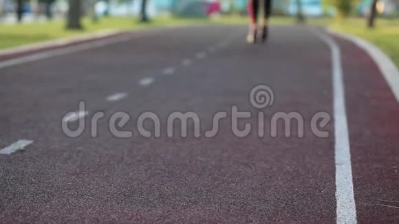 一个穿运动服装的年轻健身女孩沿着小路跑然后停下来系鞋带然后它继续运行青年视频的预览图