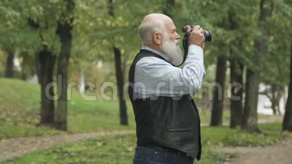 老人在公园里给大自然拍照视频的预览图