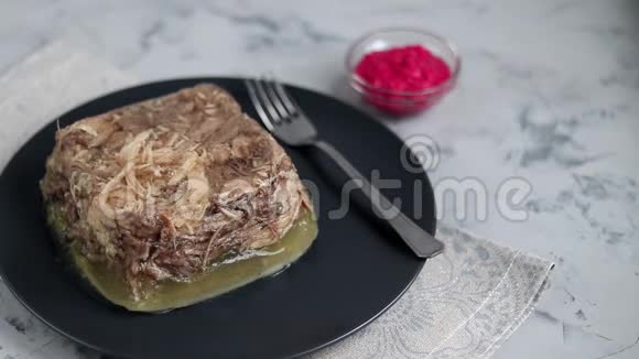 带肉猪肉和鸡肉的果冻传统的俄罗斯菜放在碗里的辣根旁边的深色盘子里视频的预览图