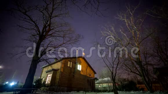 有窗户的房子动态光旋转的星星和银河旁边的房子从火中闪耀在松树上视频的预览图