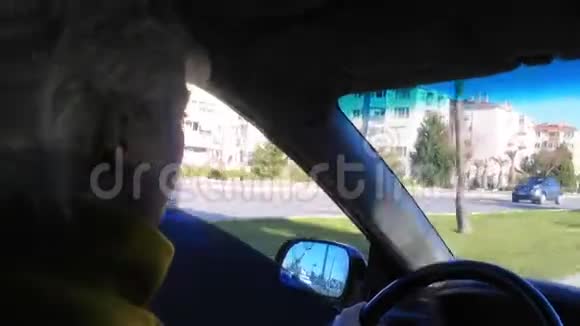 金发女郎正开着车在城里视频的预览图