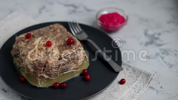 带肉猪肉和鸡肉的果冻传统的俄罗斯菜放在碗里的辣根旁边的深色盘子里视频的预览图