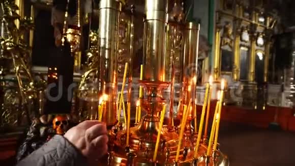 人类的手在寺庙里放了一支燃烧的蜡烛视频的预览图
