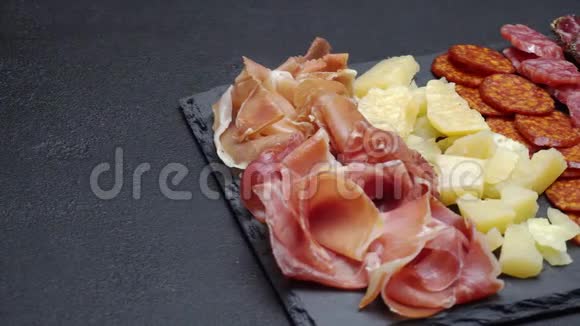 切片火腿奶酪和腊肠放在石制餐盘上视频的预览图