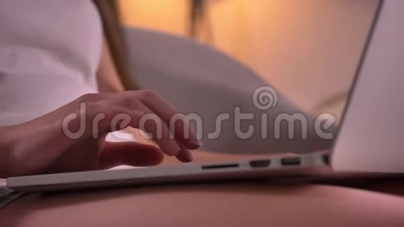 在舒适的室内家庭年轻的白种人女性手在笔记本电脑上打字的特写镜头视频的预览图