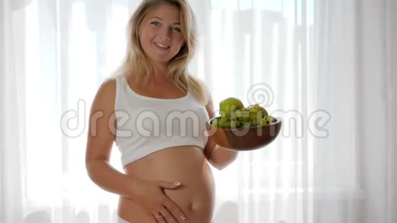 怀孕期间的营养肚子大的女性吃木盘里的葡萄视频的预览图