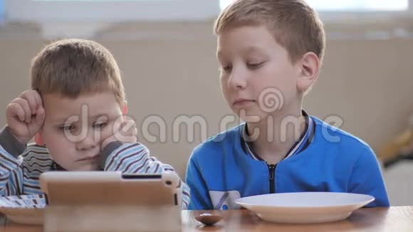 快乐的男孩在等晚餐以前看过平板电脑视频的预览图