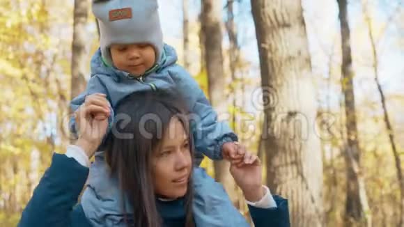 秋天公园的幸福家庭父母带着孩子在公园里散步4k视频的预览图