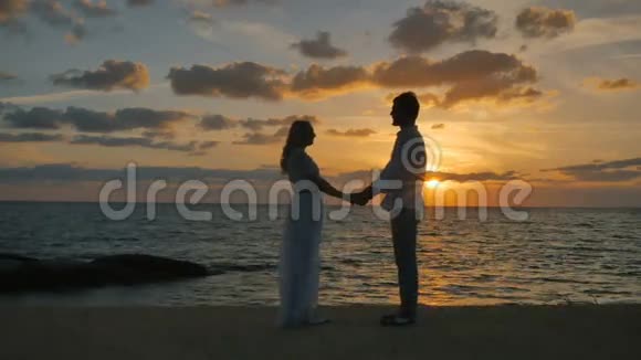 浪漫夫妇享受美丽的海景和日落视频的预览图