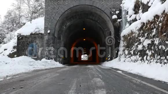 冬季风景名胜区内有古石隧道的道路视频的预览图