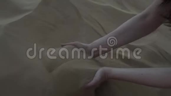 美丽的女手耙沙沙子流过手指视频的预览图