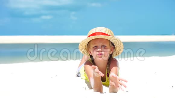 加勒比海热带度假期间海滩上戴帽子的小女孩的肖像下面的动作视频的预览图
