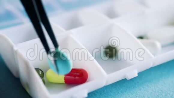 一位医生在每天的药丸盒里分发一周的药丸和药物视频的预览图