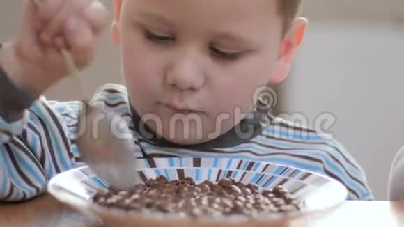 特写镜头男孩在家吃带牛奶的薄片视频的预览图