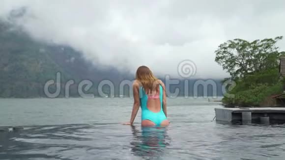 漂亮的白种人年轻女性在游泳池里享受休闲时光视频的预览图
