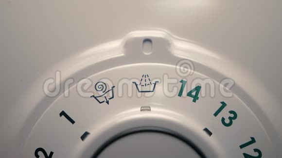 人通过旋转洗衣机的选择器来选择洗涤程序视频的预览图