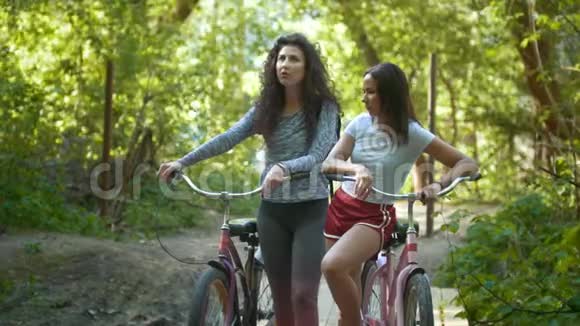 公园里两个女人骑着自行车夏日视频的预览图