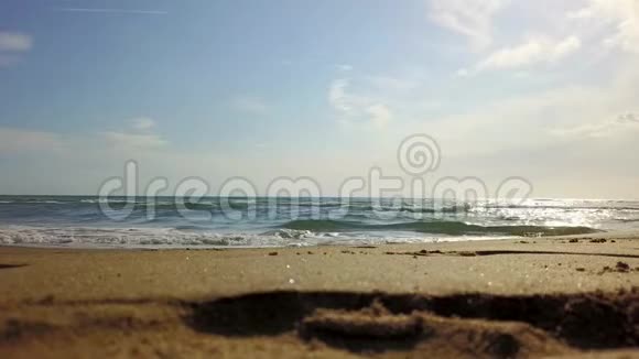 在蓝天下海浪在海滩上翻滚视频的预览图