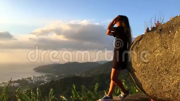 年轻的旅游女孩在观景台观看惊人的日落慢动作旅行动机视频泰国普吉岛视频的预览图