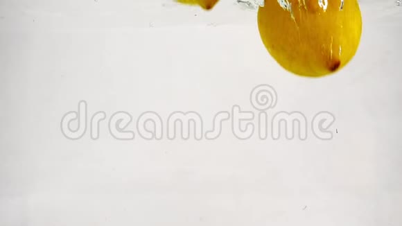 白色背景下的柠檬慢动作视频成熟的黄色水果浸泡在水中有气泡视频的预览图