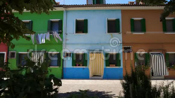 五颜六色的街道有五颜六色的房子洗衣房在风中干燥绿色植物视频的预览图