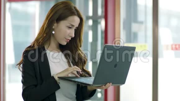 在电梯厅使用笔记本电脑的亚洲商界女性视频的预览图