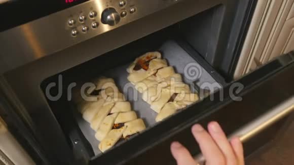 男性用手关上烤箱的门里面有生巧克力派视频的预览图