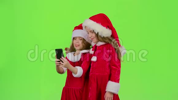 穿着新年服装的小女孩在电话里自拍绿色屏幕视频的预览图