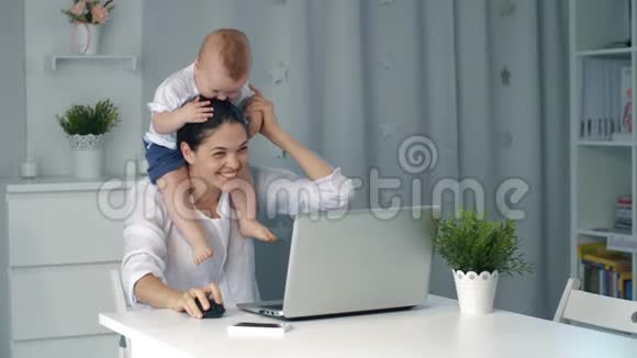 妈妈带着孩子在家里做笔记本电脑视频的预览图