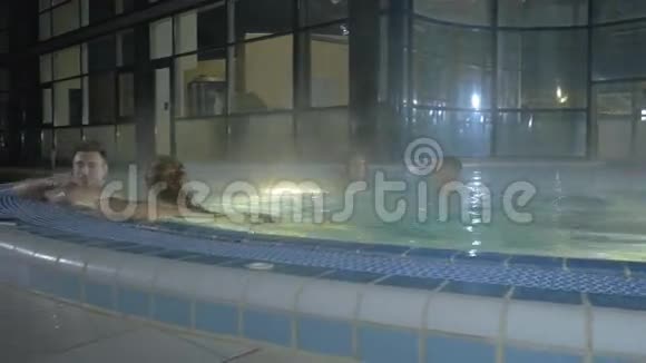 有魅力的男人和漂亮的女孩在游泳池旁边游泳视频的预览图