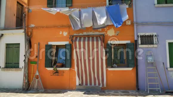 旧橙色房子的Shabby门面有烘干洗衣和捕鱼设备视频的预览图