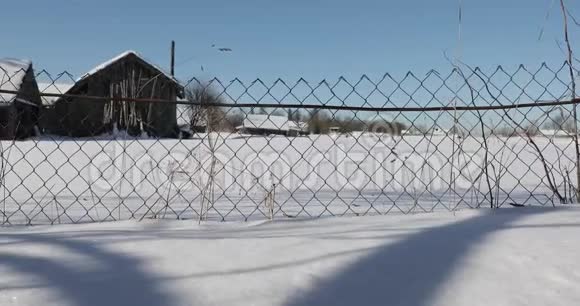 冬天村庄里的栅栏网从右到左的平滑运动视频的预览图