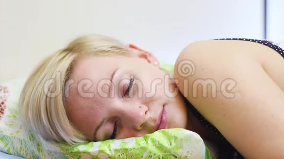 早上睡在床上的年轻金发美女视频的预览图